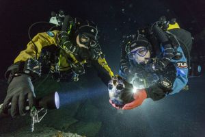 In a flooded cave in Mexico, divers transport a skull for 3-D scanning. Between 12,000 and 13,000 years old, the skull is part of the most complete skeleton of such antiquity yet discovered in the Americas. PHOTOGRAPH BY PAUL NICKLEN, NATIONAL GEOGRAPHIC