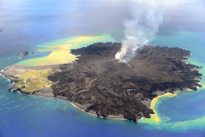 The new volcano (black material) is taking over the old island (green and yellow portion of the island).